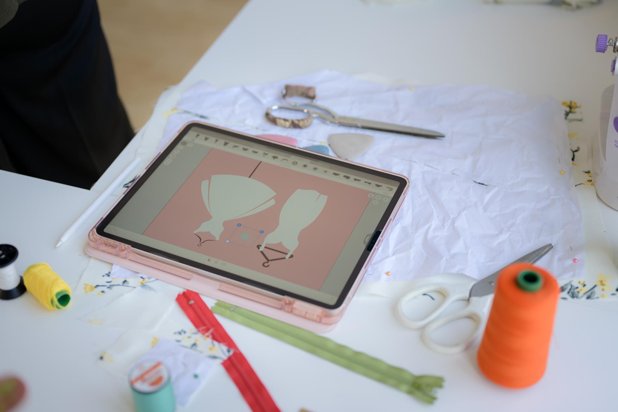 Workspace with threads, hoops and digital pattern tablet